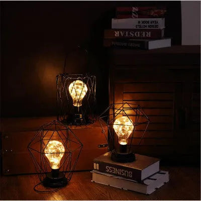 Minimalist hollow wrought iron table lamp in red wine bottle design with warm white LED light.