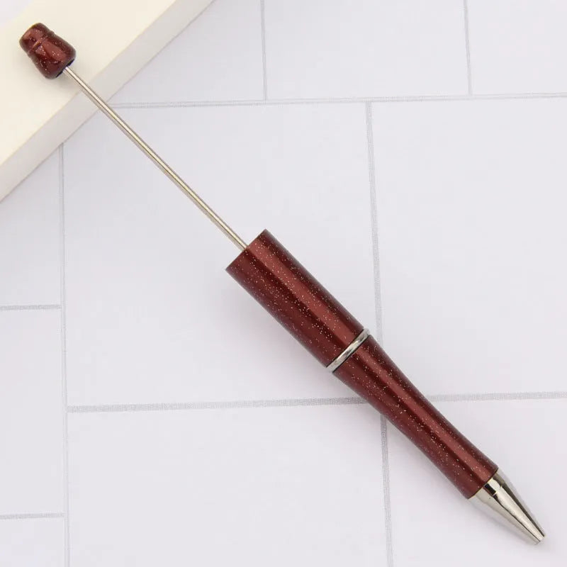 Colourful spinning ballpoint pen with plastic beads on a white background.