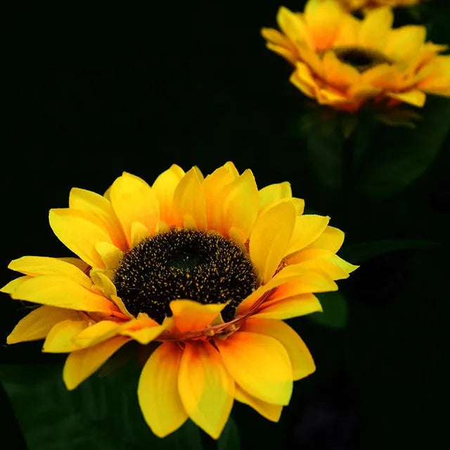 LED solar sunflower lamp with yellow fabric flower head, 66cm stainless steel stem, and ABS ground plug, placed on grass