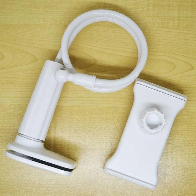 Black aluminium alloy bedside phone handset with a long arm and wide clamp, holding a mobile phone above a bed.
