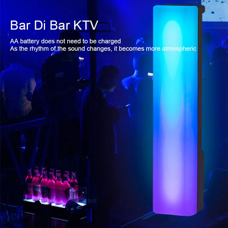 A tall, colourful RGB table lamp with a white or black shell reacting to sound on a desk.