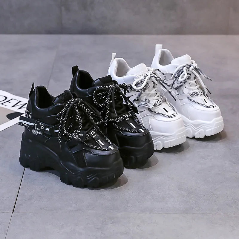White women's low-top platform sports shoes with cross-strap detail on a rubber sole.