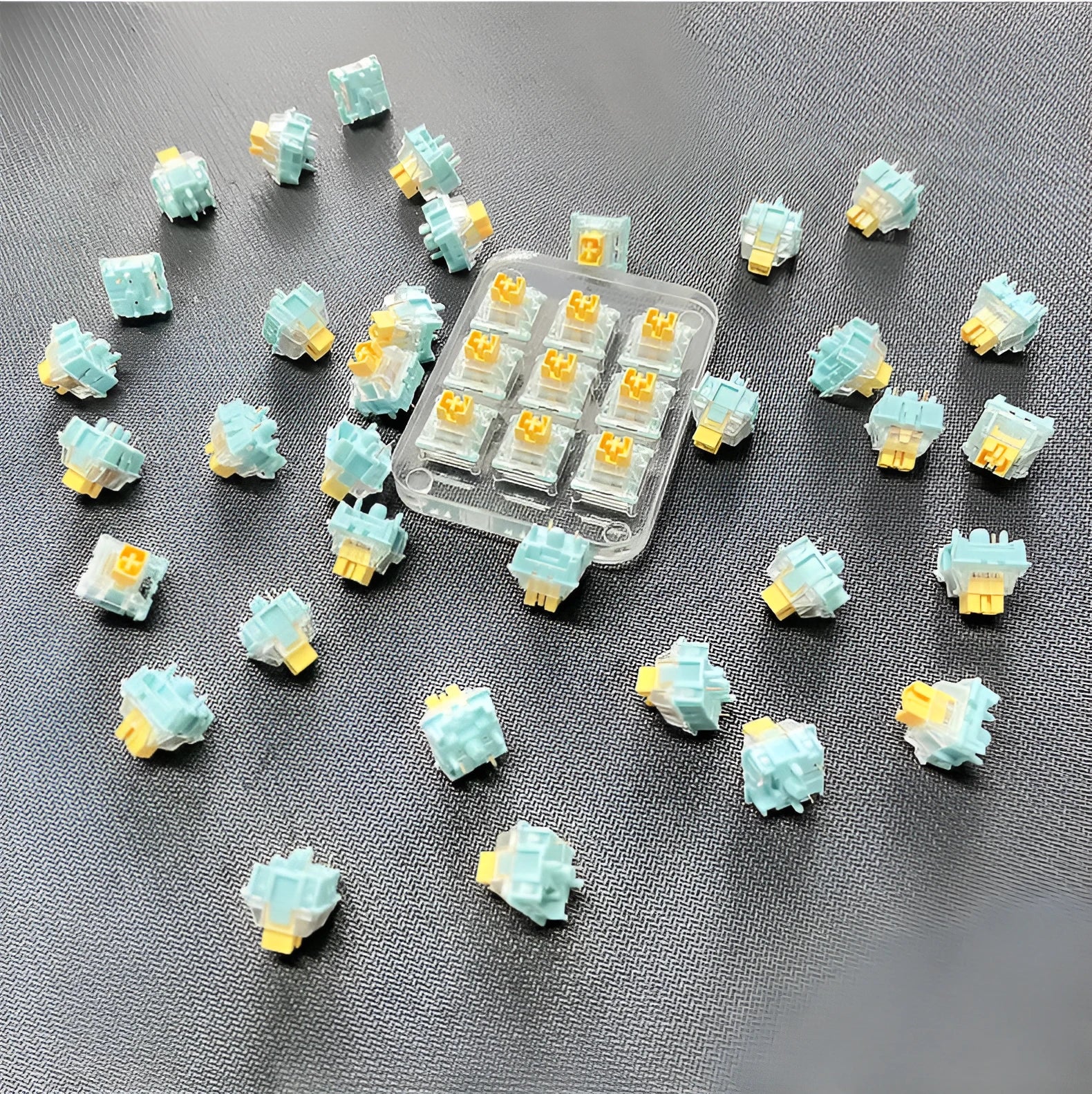 36 Sea Salt Lemon coloured mechanical keyboard switches with 3-pin connectors laid out on a table.