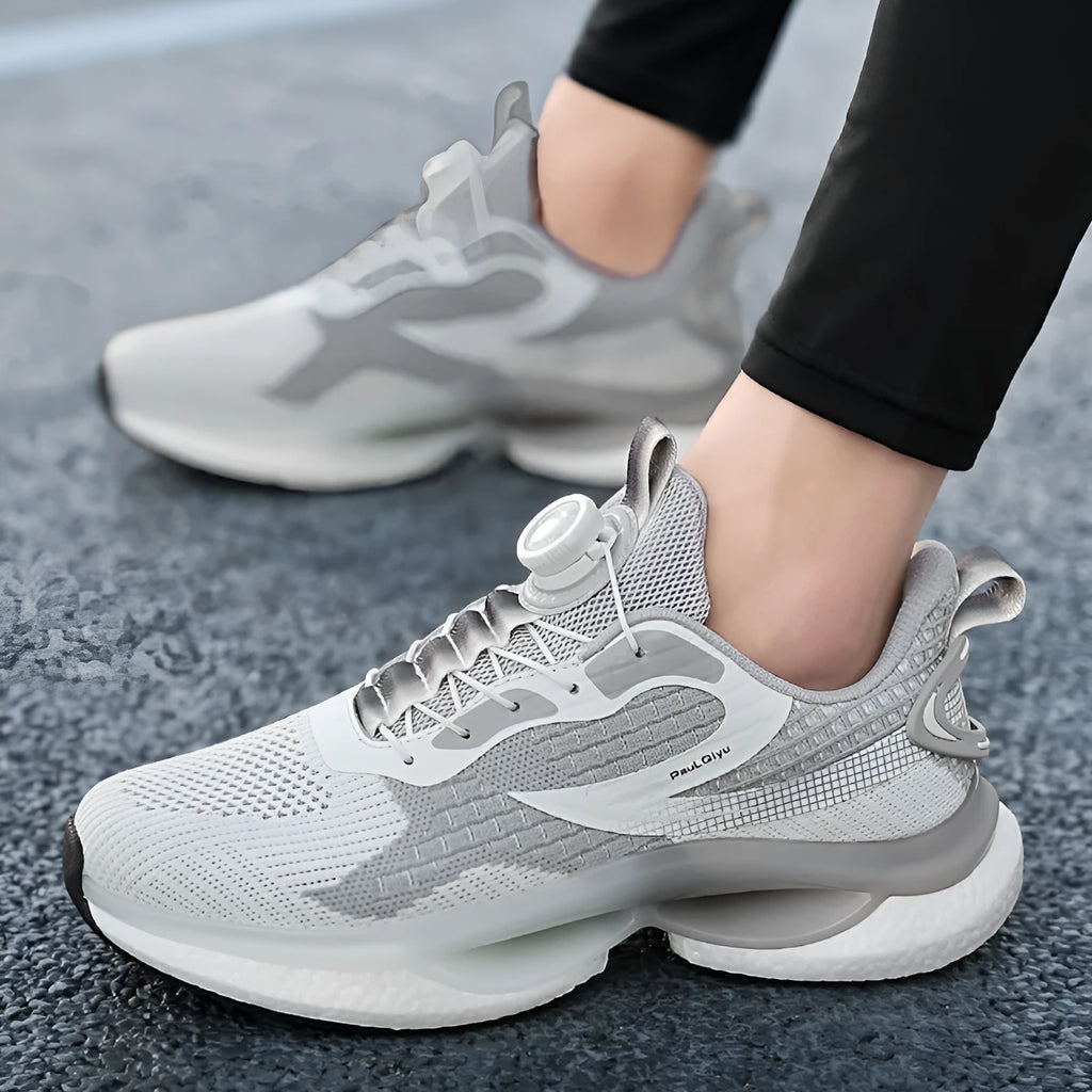 Low-top white running shoes with a rotating button buckle on a breathable mesh upper and a textured TPU sole.