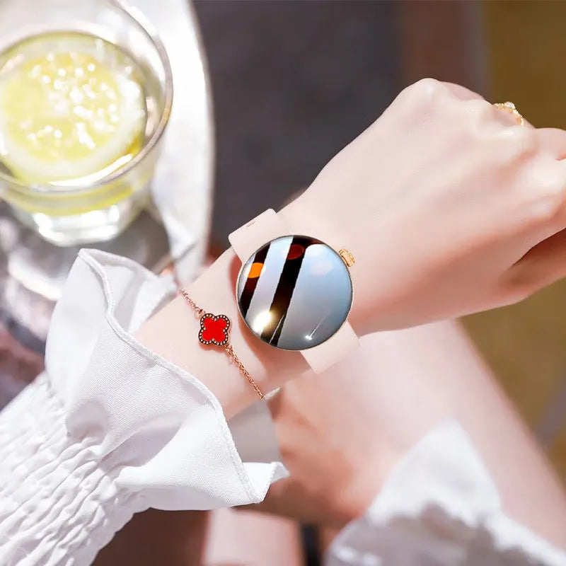 Circular smart watch with metal strap on a woman's wrist, showing colour touchscreen display.