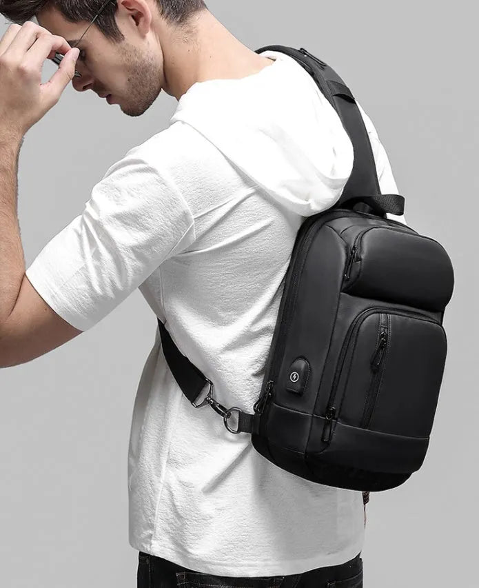 Black square vertical PVC shoulder bag showing organiser pockets and air cushion strap.