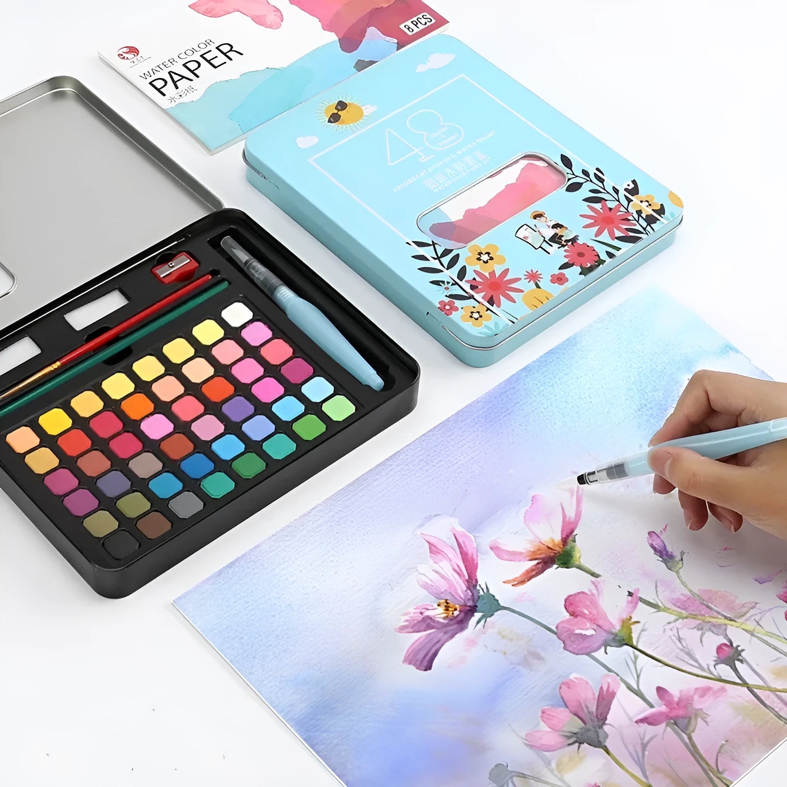 Open box showing 48 solid watercolour paint cakes in various colours including black knight, pink, and blue.