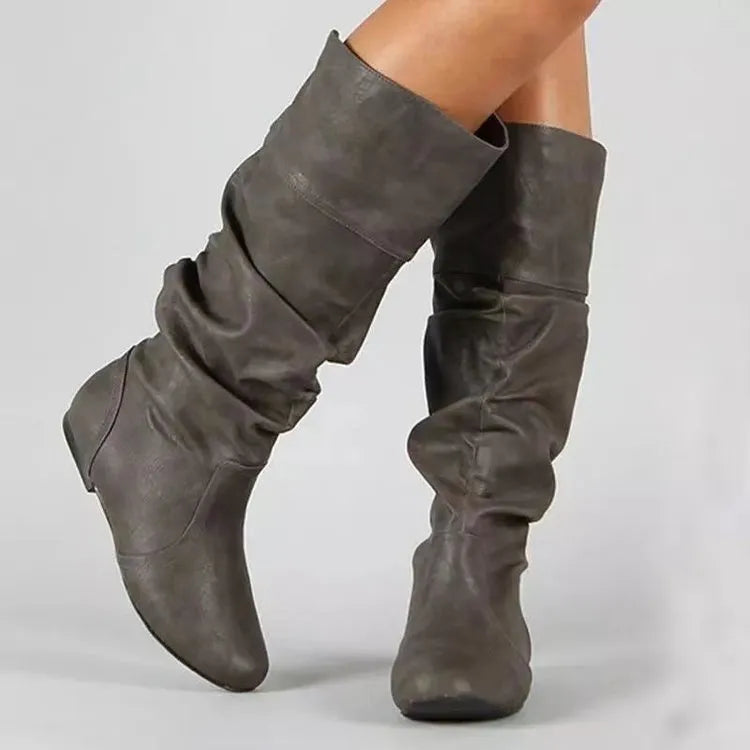 Women's flat slip-on long boots in black with round toe and high cylinder shaft, on a rubber sole.