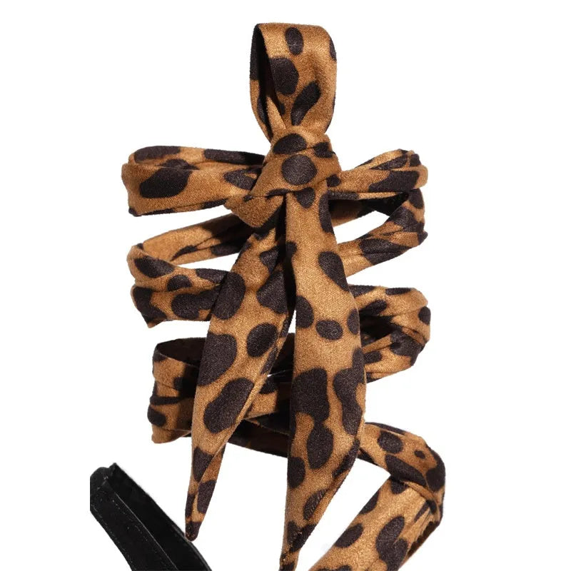 Light brown leopard print women's high heels with cross straps and an 8cm slim heel on a rubber sole.
