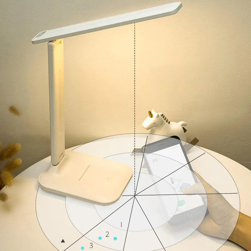 White plastic bedside lamp with touch dimming and colour-changing LED light on a table.