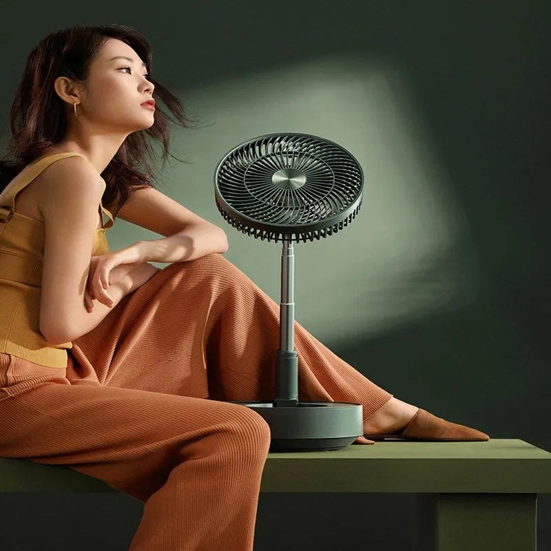 Green telescopic floor fan extended to full height with magnetic remote control attached