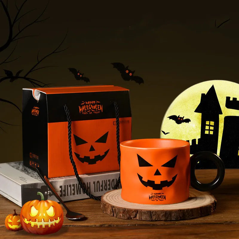 Orange ceramic pumpkin mug with handle on gift box with dessert spoon