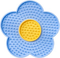 Flower-shaped silicone lick mat for dogs and cats with suction cups on a blue background.