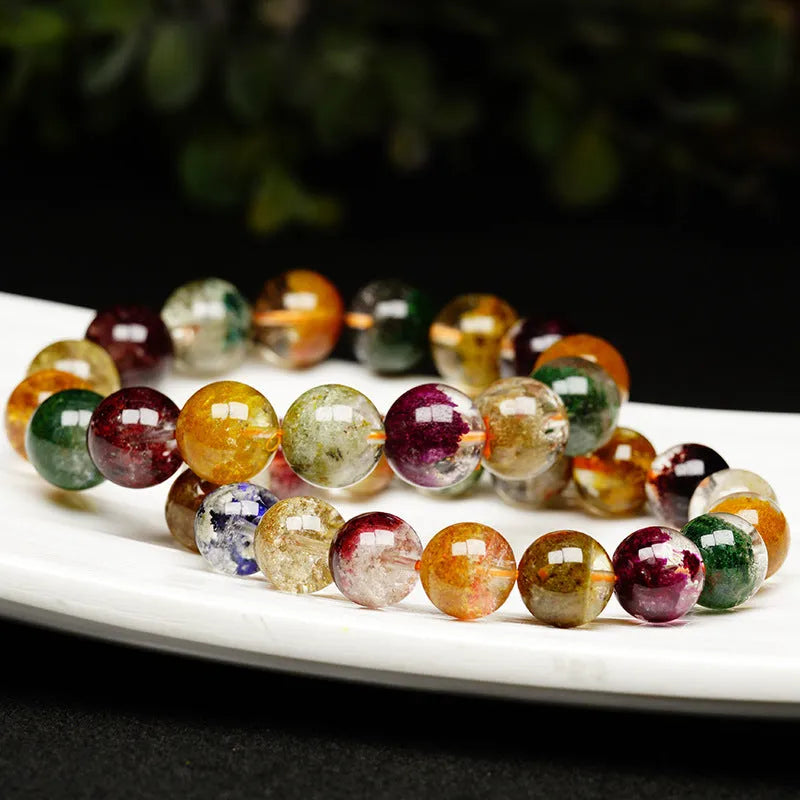 Colourful ghost cornucopia crystal bracelet with 10mm beads on a wrist.