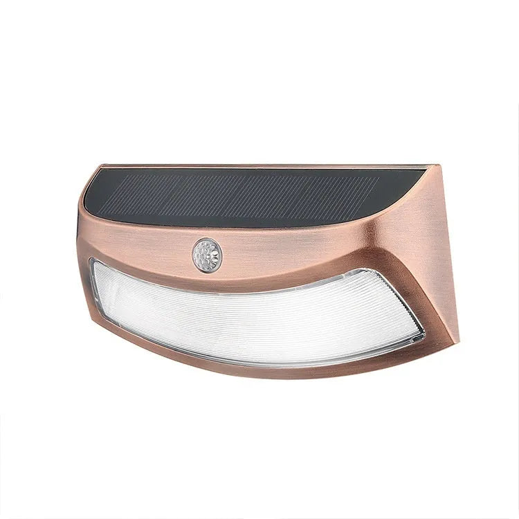 Solar-powered outdoor wall lamp with a smiling face design in a garden setting.
