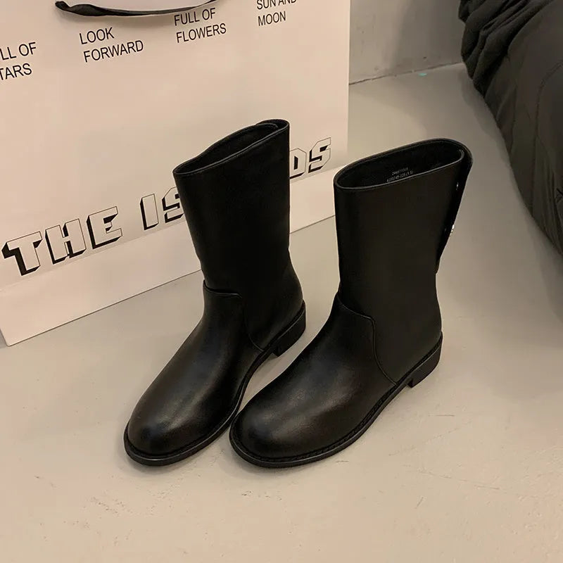 Women's black leather mid-calf platform boots with silver stud details on a white background