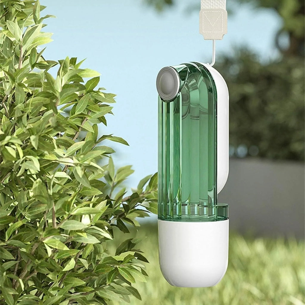 Beige and green foldable dog water bottle with food container, showing scale next to a dog's muzzle.