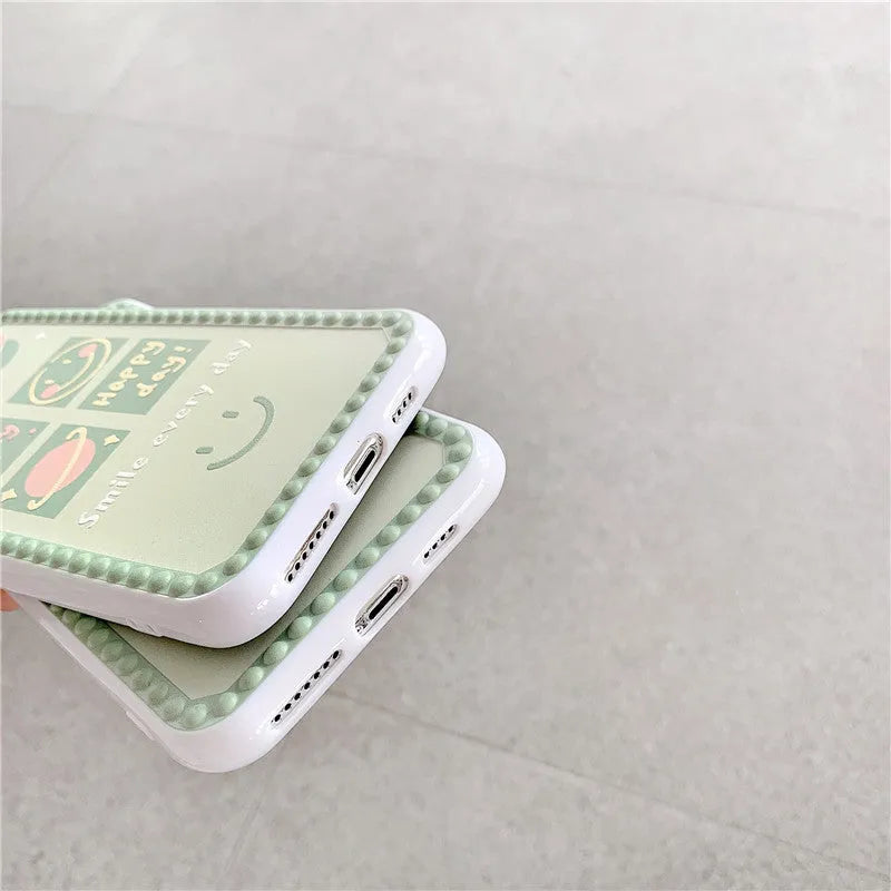 Green TPU iPhone case with geometric smiley face design and polka dot frame.