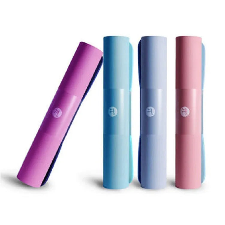 Paido TPE yoga mat in Pink Grey colour rolled out on a wooden floor with a yoga block nearby