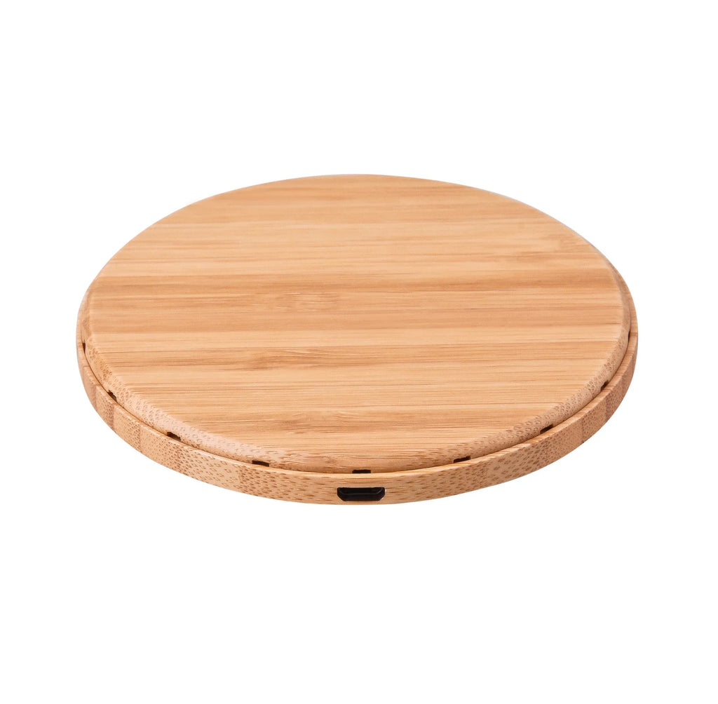Natural bamboo wireless charger pad on desk with a smartphone placed on it
