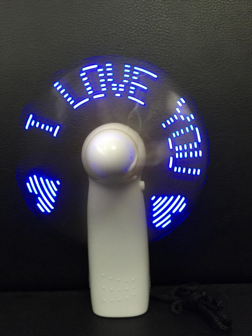 White handheld mini fan with flashing blue and red LED 'I Love You' pattern on display.
