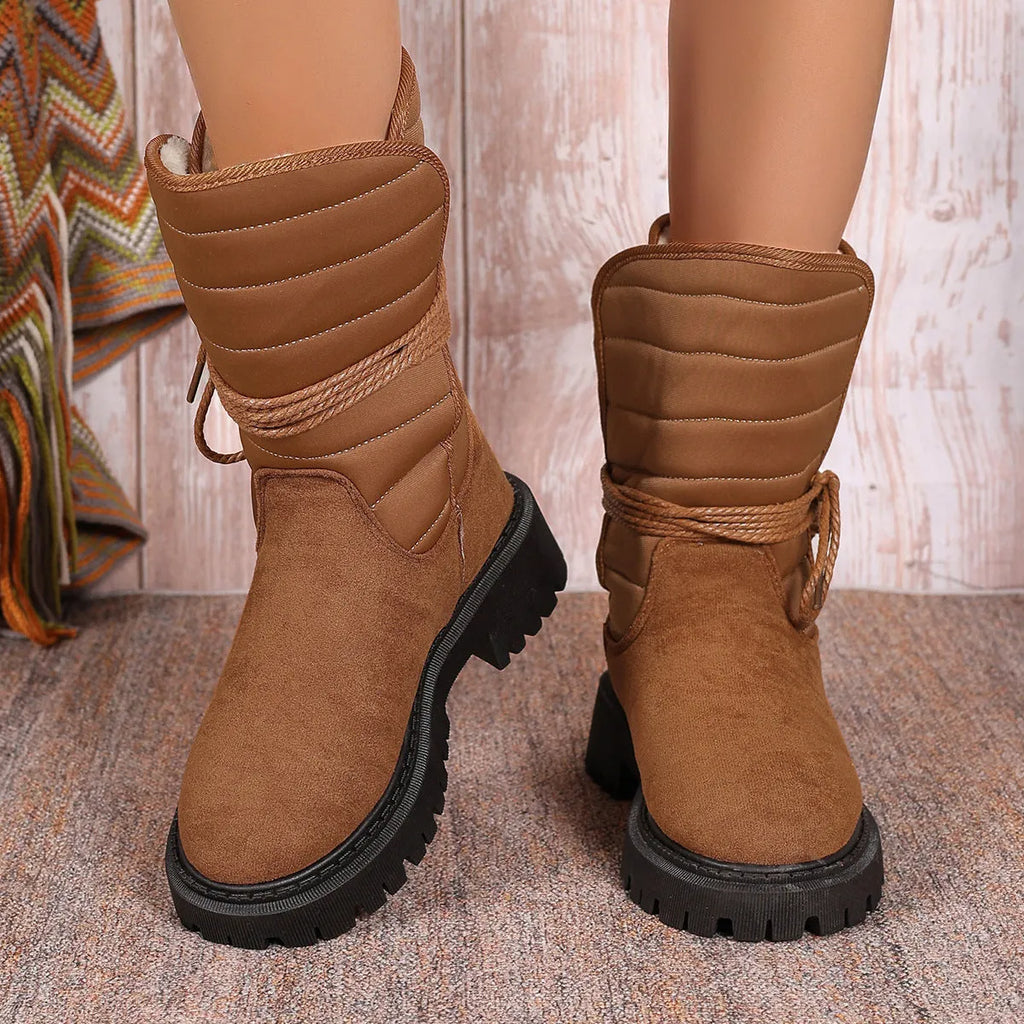 Women's black suede chunky heel snow boots with lace-up design and fleece lining on a neutral background.