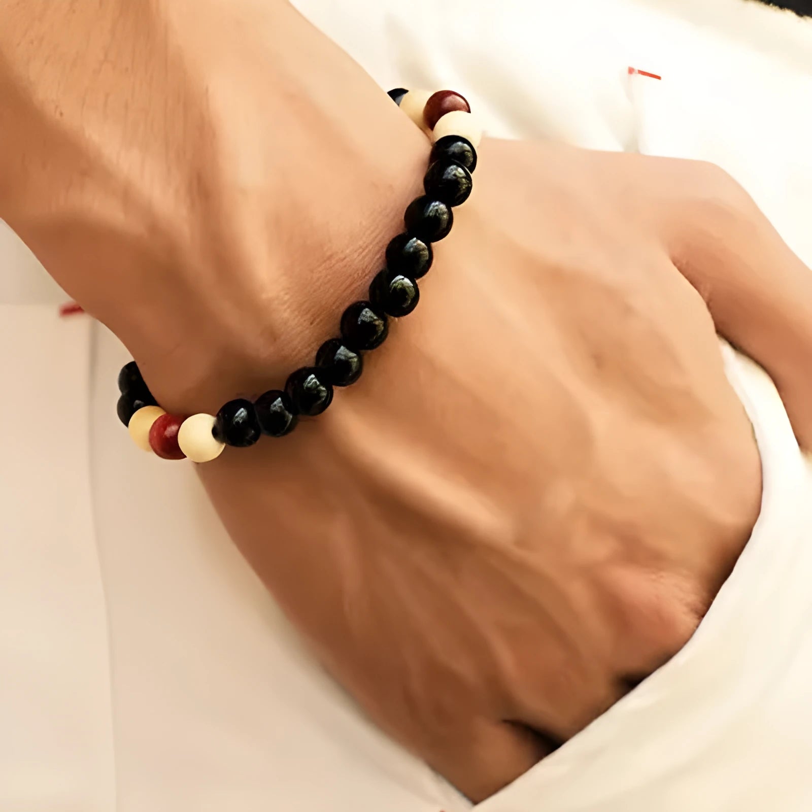 Natural lava stone beaded bracelet for men and women on a neutral background.