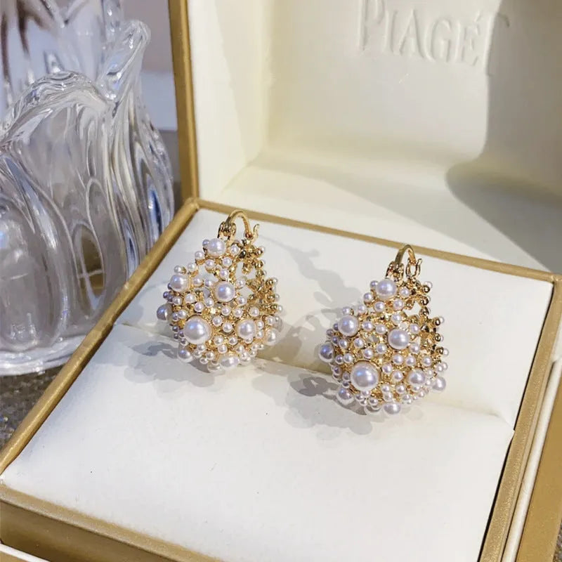 Gold tone women's flower basket earrings with small rice-shaped beads and pearl inlay detail