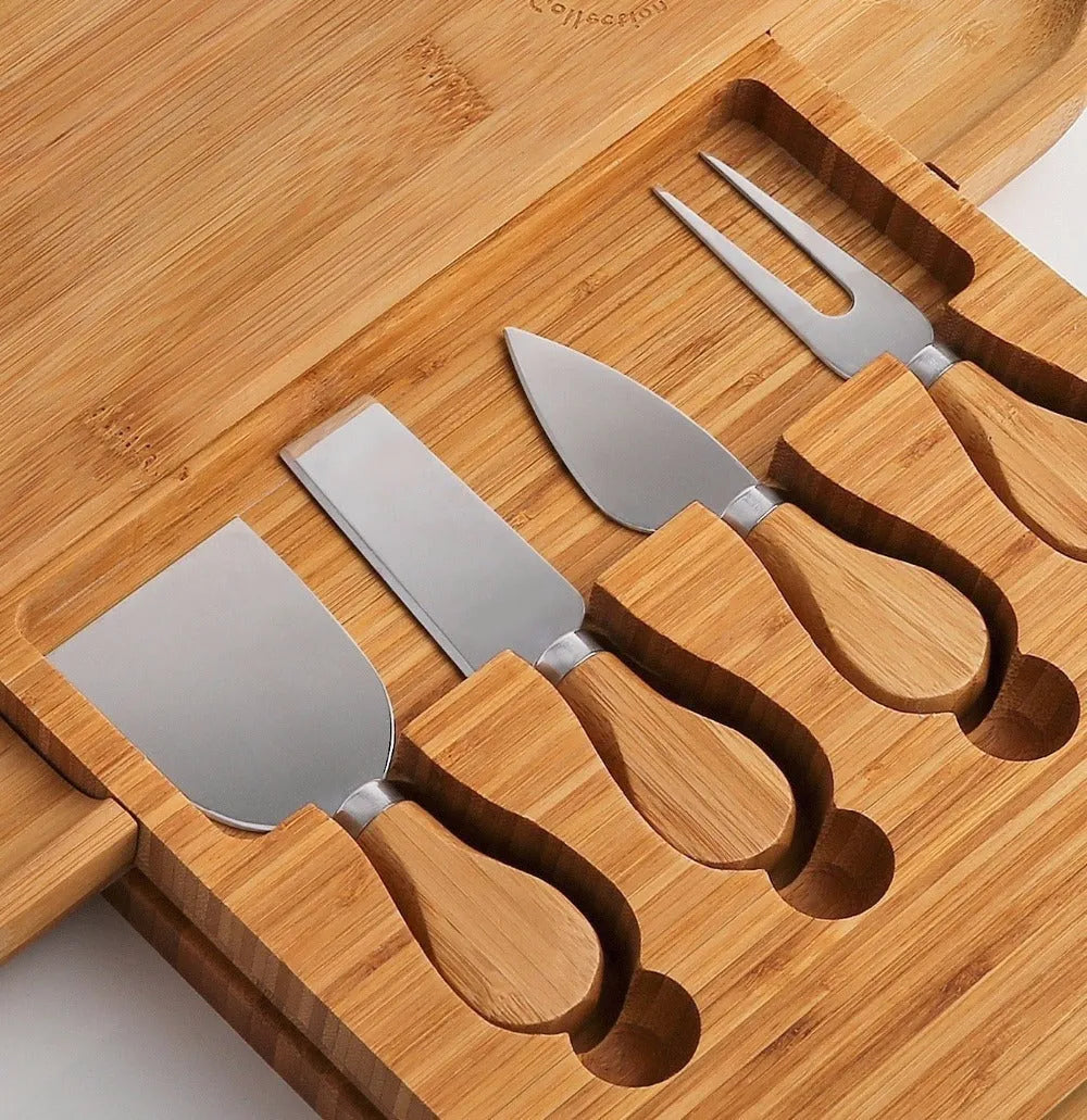 Square bamboo cutting board with drawer holding four-piece knife and fork set in wood colour