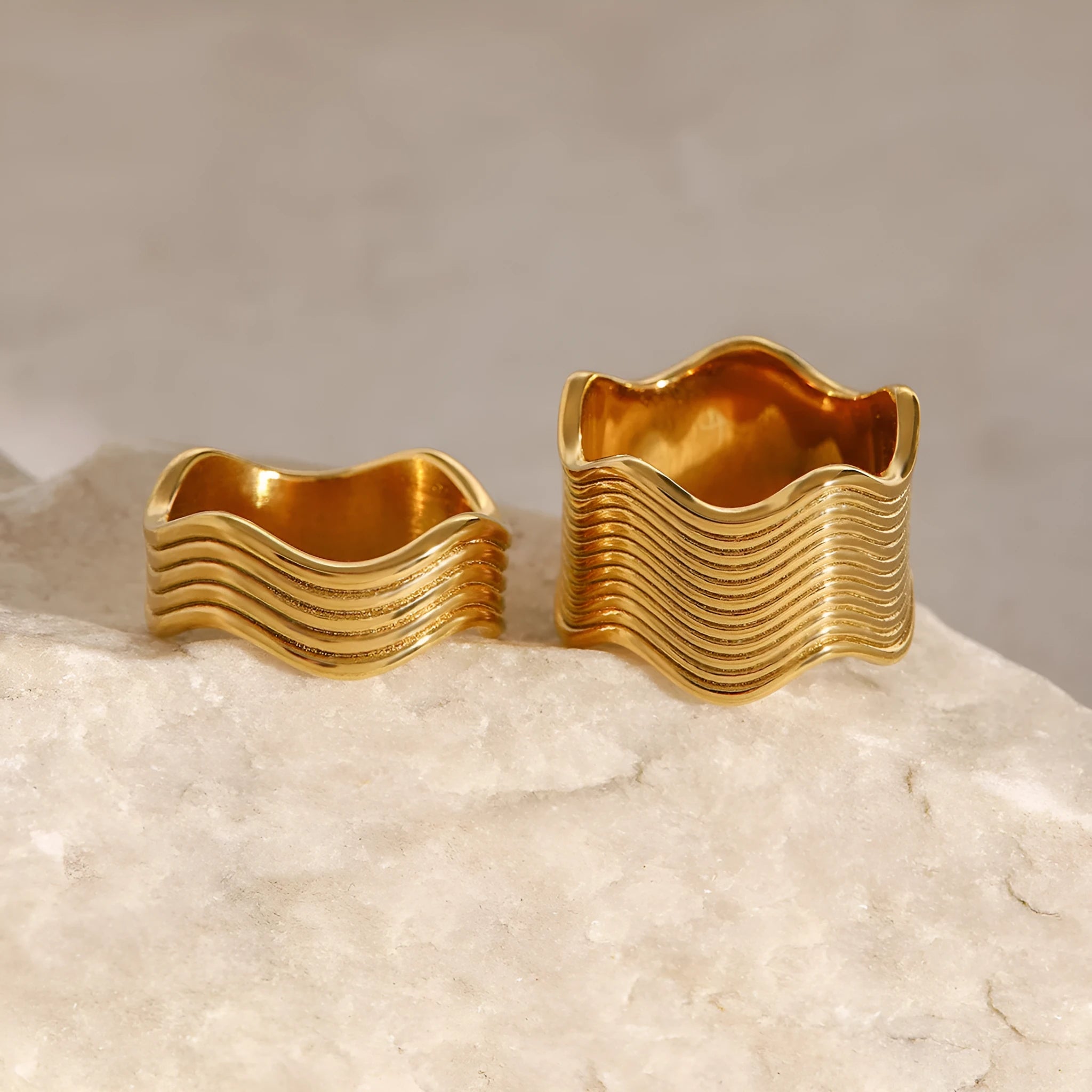 Stainless steel wide band ring with a geometric wave pattern, shown in an electroplated colour option.