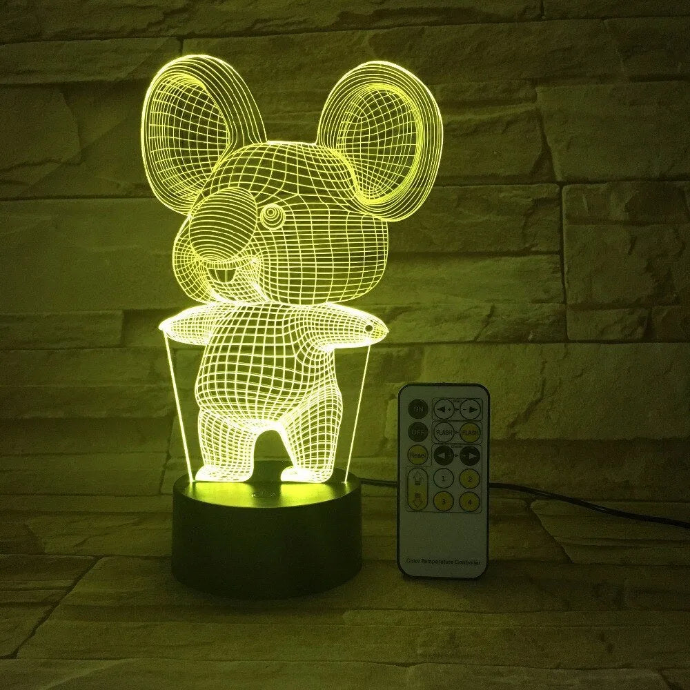 Koala-shaped night light with remote control showing seven colour options on a bedside table