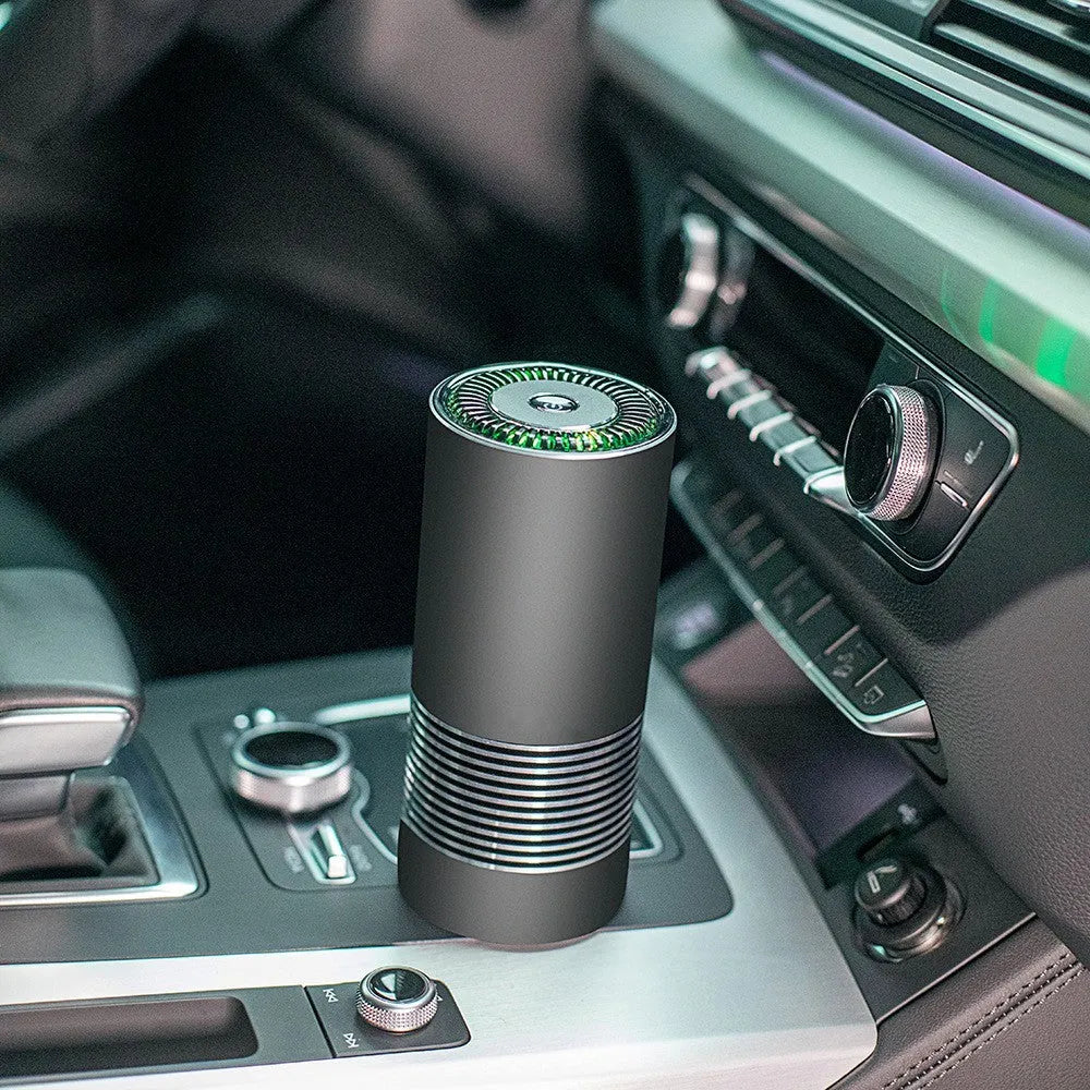 Compact black car and desktop air purifier with aluminium alloy case on a wooden desk.