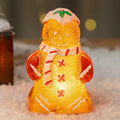 Glowing plastic gingerbread man Christmas ornament with LED light and scarf, in four colour variations.