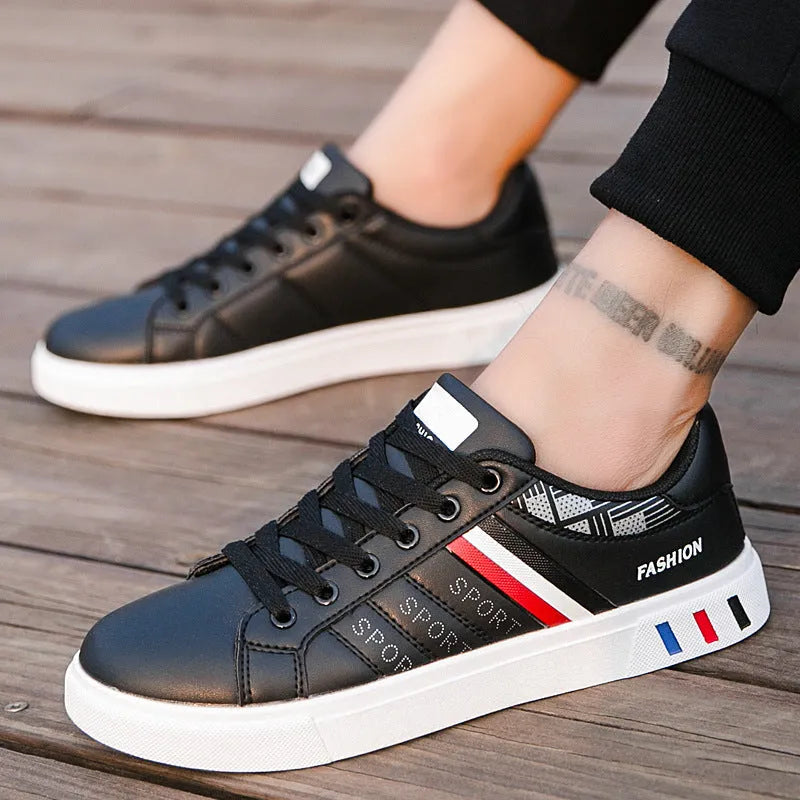 Men's black sports shoes on a white background, showing the classic trainer design and rubber sole.