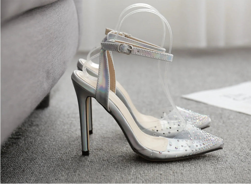 Women's pointed toe stiletto heel sandals with a glossy PVC upper and an ankle strap buckle.