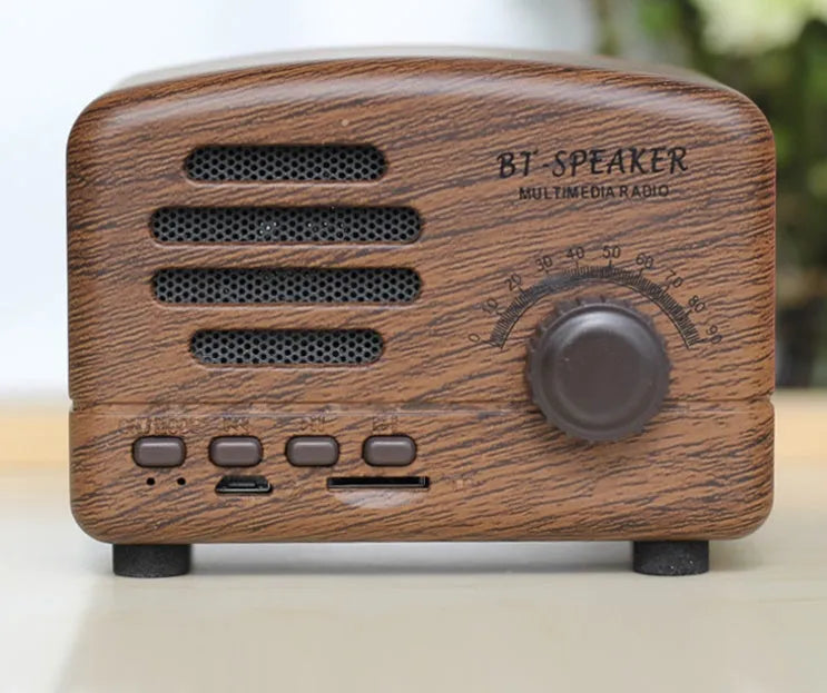 Compact vintage wood-grain finish Bluetooth speaker with control buttons on top.