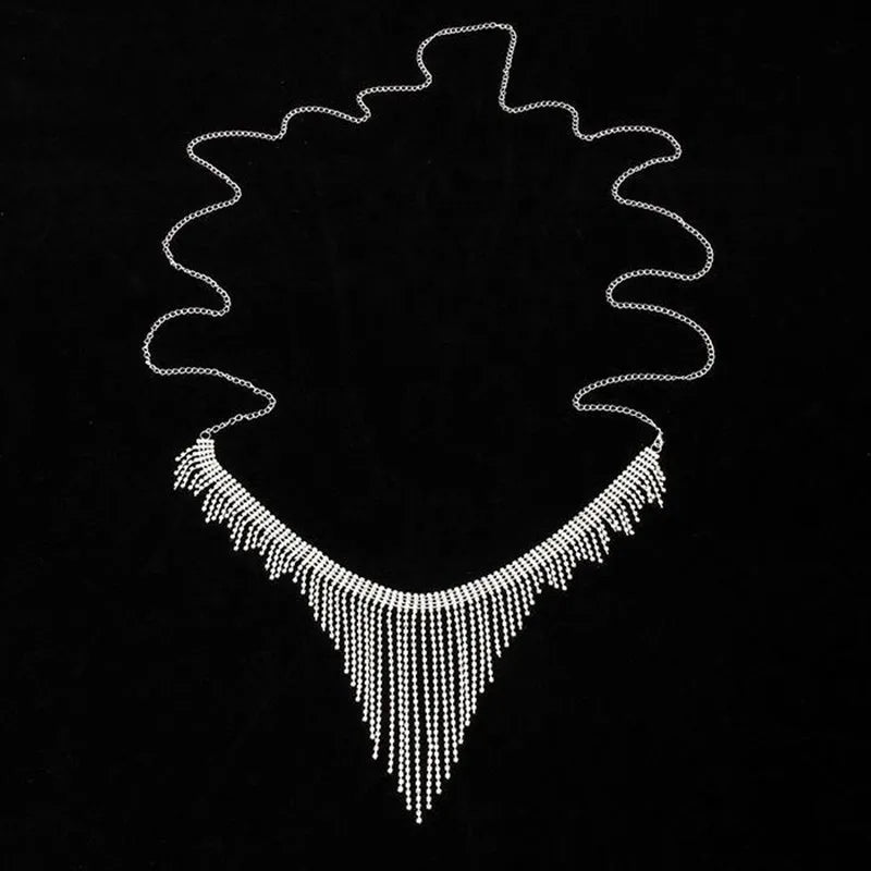Silvery rhinestone body chain laid flat on a white surface showing metal links and clear stones