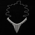Silvery rhinestone body chain laid flat on a white surface showing metal links and clear stones