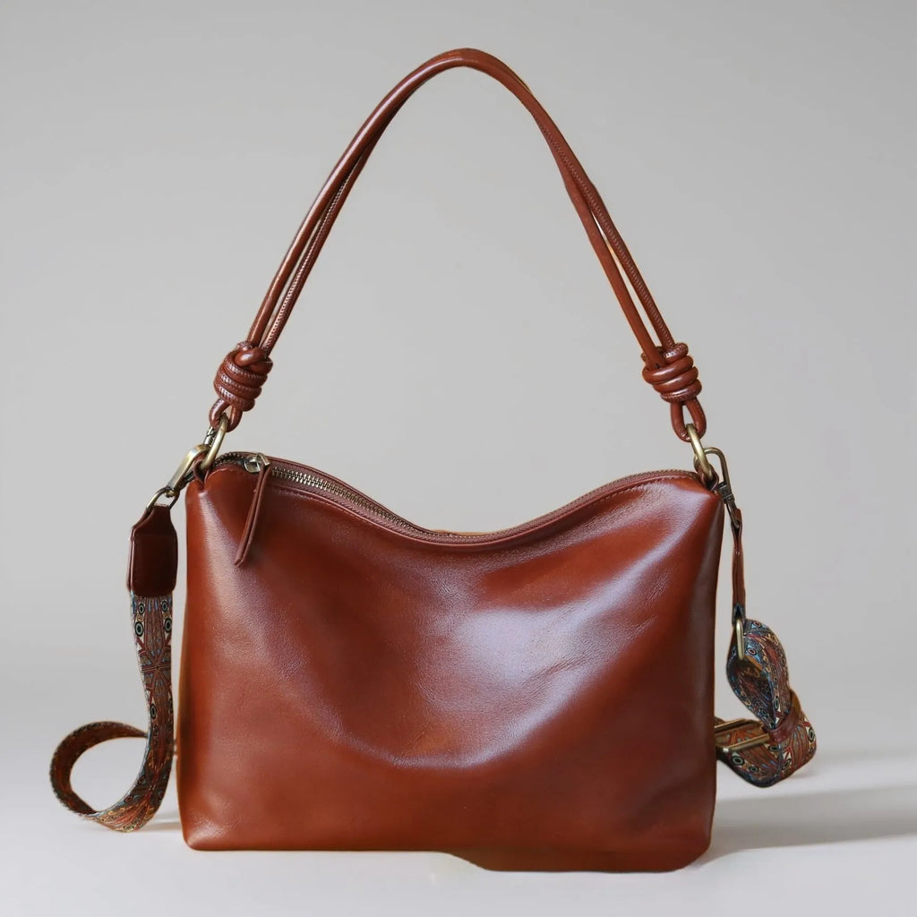 Genuine leather pillow-shaped commuter bag in caramel colour with double straps and patchwork detailing, 31x11x24cm