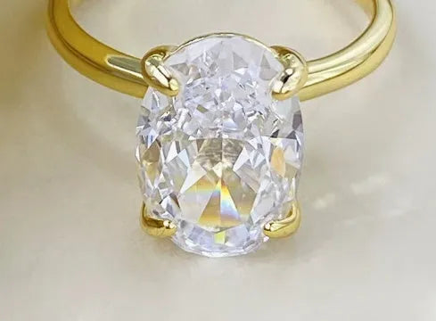 A women's oval sterling silver ring with a four-claw setting holding a single stone.