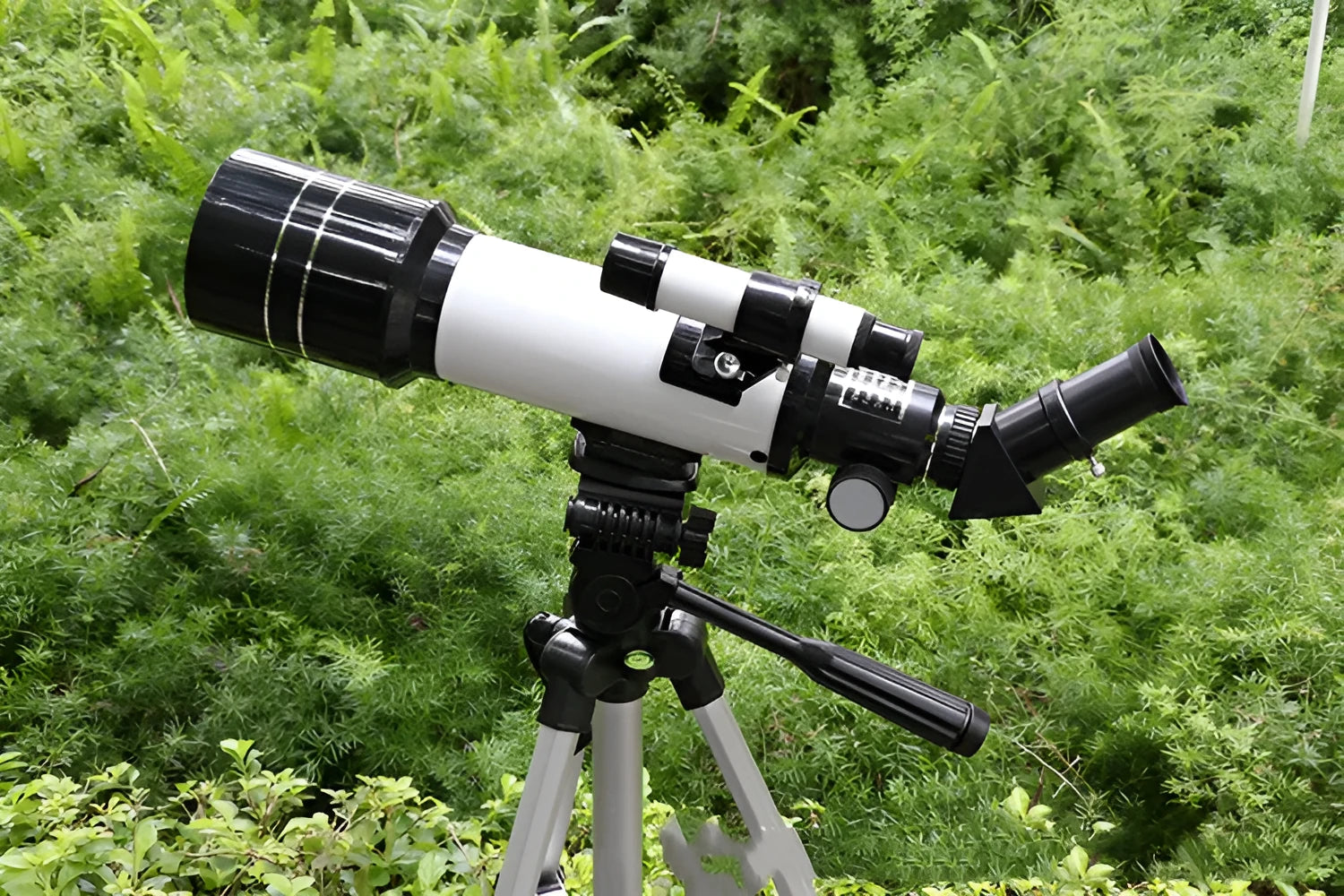 Dark blue and white children's astronomical monocular telescope on a tripod with optional phone holder accessories.