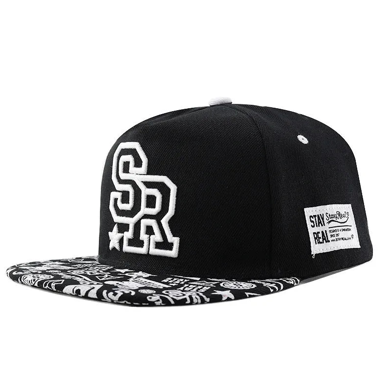 White and black adjustable cotton baseball cap with embroidered letters on the front, showing dome crown and adjustable strap.
