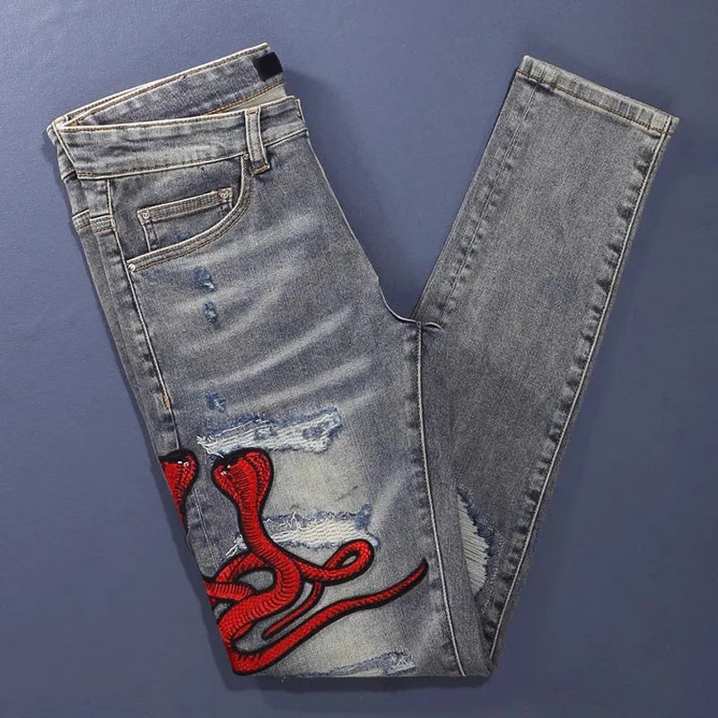 Old colour slim fit jeans with washed-out finish, patch details, and embroidery on cotton fabric.