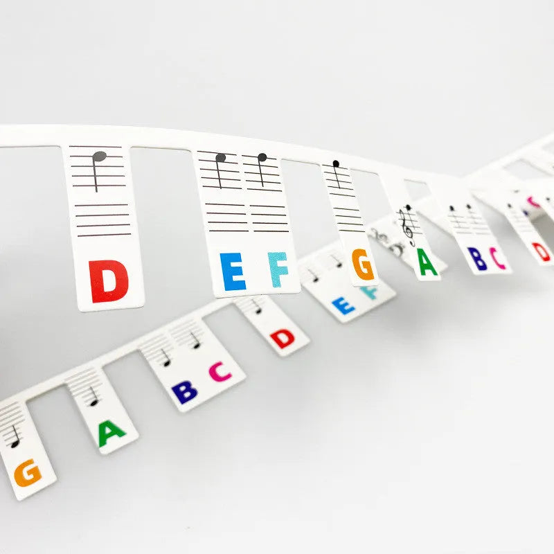 White cardboard piano note stickers for 88-key keyboards with black notes and colour bars in separate bags