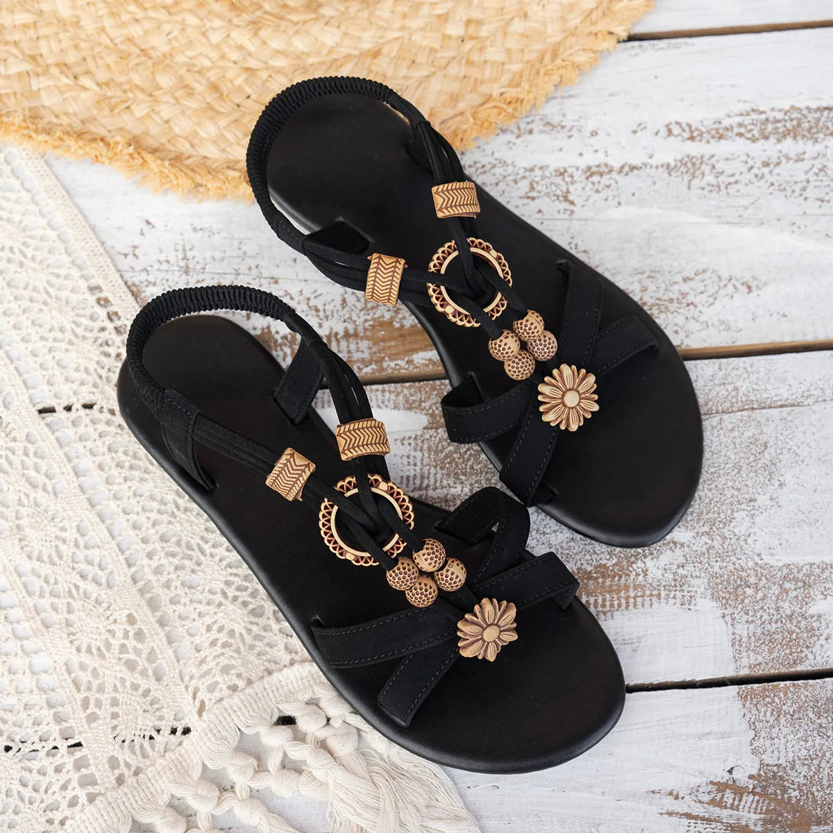 Black women's flat open-toe beach sandals with beaded weave upper, rhinestone decoration, and elastic band.