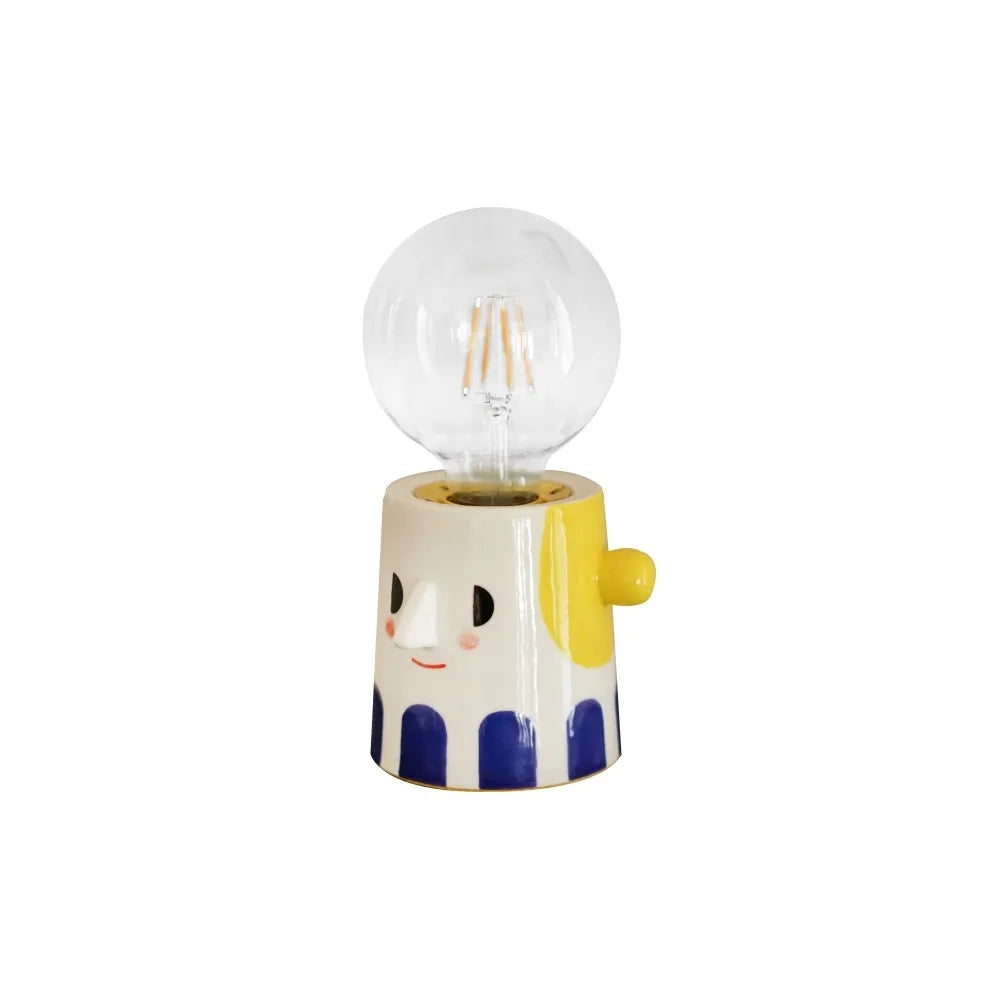 Handmade ceramic table lamp with white spherical shade on a wooden surface.
