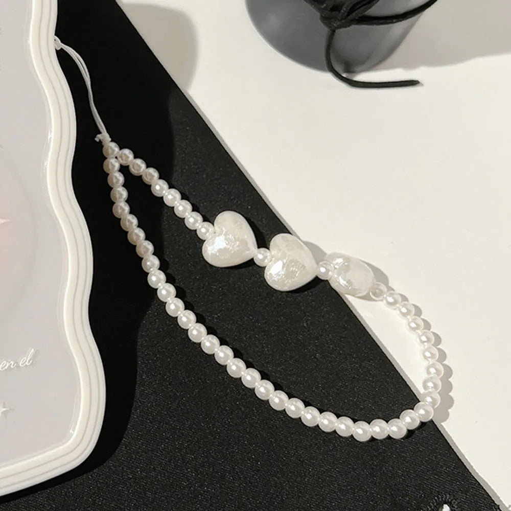 Transparent iPhone case with raised ice-through bow design and white love lanyard attachment