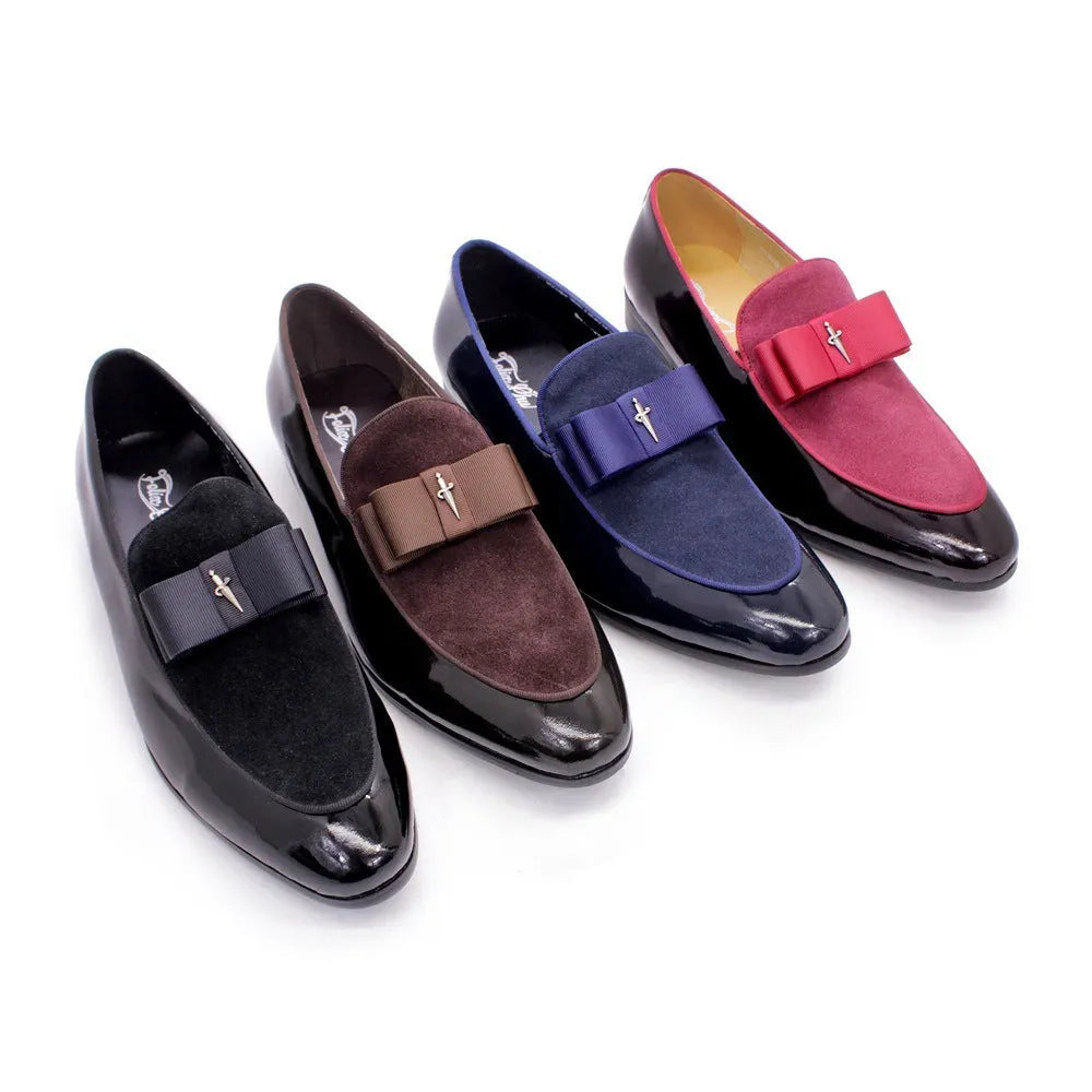 Men's black tassel loafers with matte and glossy patent leather uppers and a rubber sole, shown on a wooden surface.