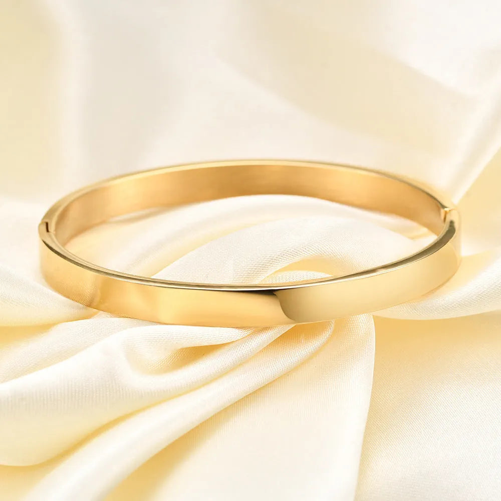 Stainless steel snap bracelet with polished finish in gold colour on a white background