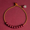 Hand-woven bracelet made of red cinnabar and raw Hetian Jade in a simple geometric shape.